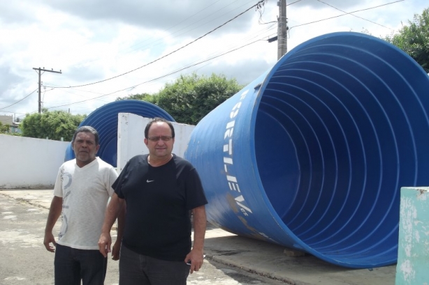 O prefeito Oninho, de camisa azul, com um t&eacute;cnico da prefeitura, ao lado de um dos reservat&oacute;rios adquiridos