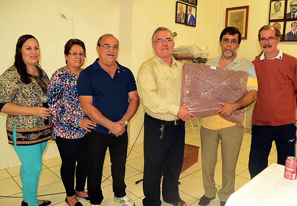 Sebasti&atilde;o Tat&aacute; recebe um dos cobertores das m&atilde;os do presidente do Lions Clube, Geraldo Luchini