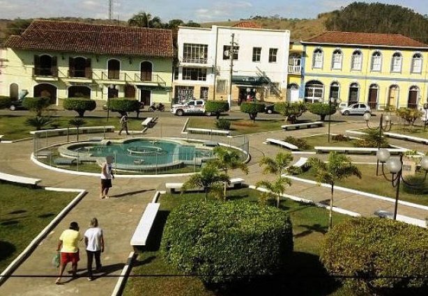 Do outro lado da praça, vê-se a viatura policial quase em frente a agência do Sicoob