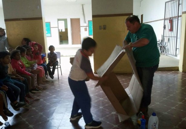 Juninho Teixeira na escola em Vista Alegre, com um aluno orientando sobre produtos recicláveis