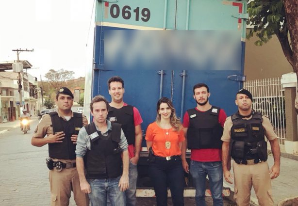 A delegada Flávia Granado, ao centro na frente do caminhão recuperado, com policiais que participaram da operação.