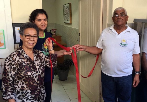 Adão, presidente da APAE Cataguases corta a fita inaugural do Centro Dia ao lado de dona Marlene e de uma aluna daquela escola