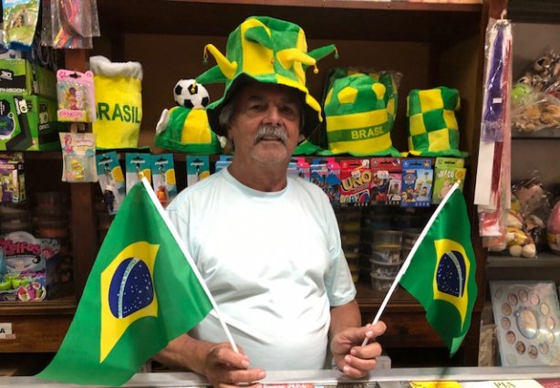 Arlindo, proprietário da Loja Estrela, posa com alguns dos produtos alusivos à Copa do Mundo 